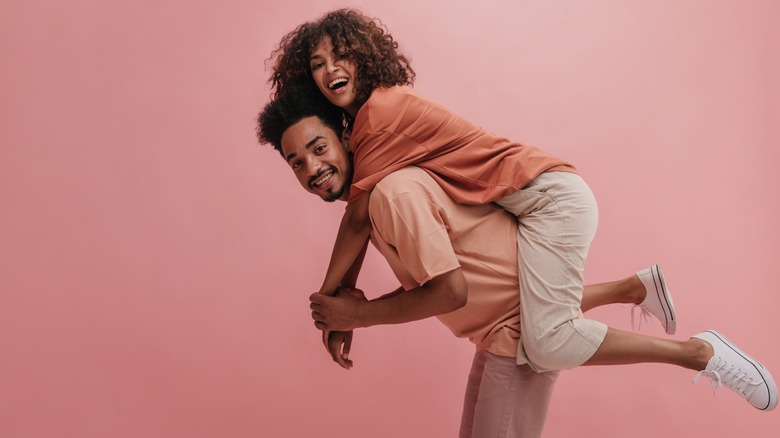 a man giving a woman a piggyback ride 