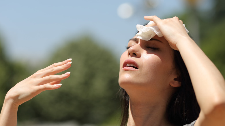 woman wiping sweat from her forehead