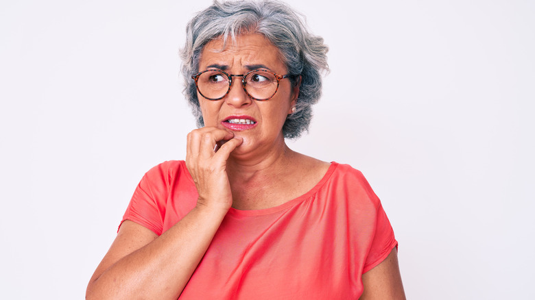 Stressed woman holds hand on face