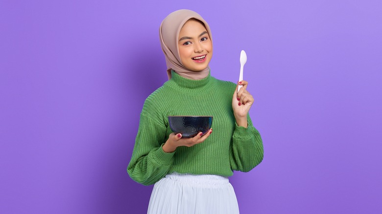 a woman holding a bowl of food 