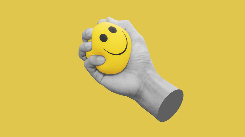 floating hand holding smiling stress ball