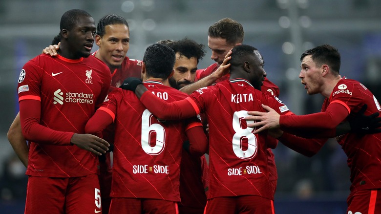 Men in red jerseys huddled on a sports field.