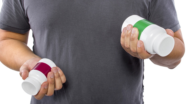 Man comparing bottles of medicine