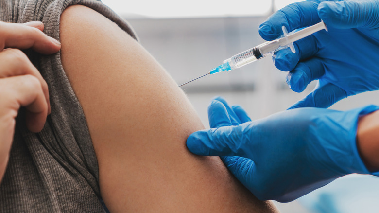 Healthcare provider injecting man's arm