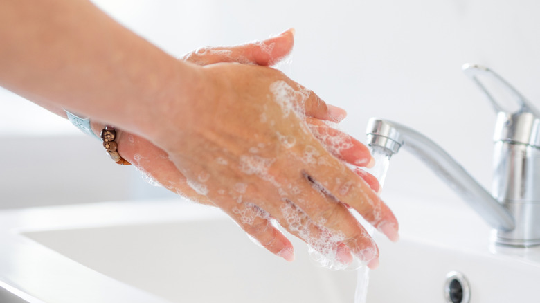 washing her hands in public restroom