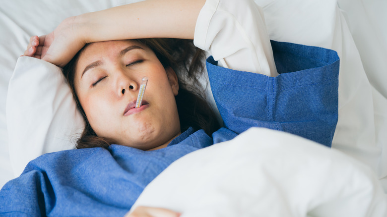 a hospitalized woman with a thermometer
