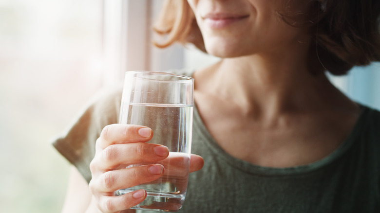 Woman holding glass of water