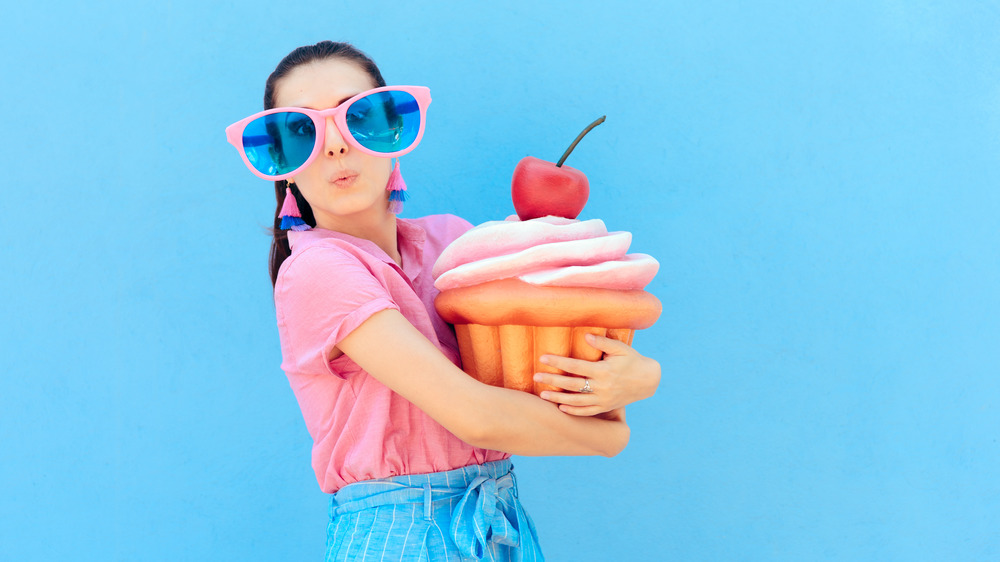 woman clutching giant cupcake