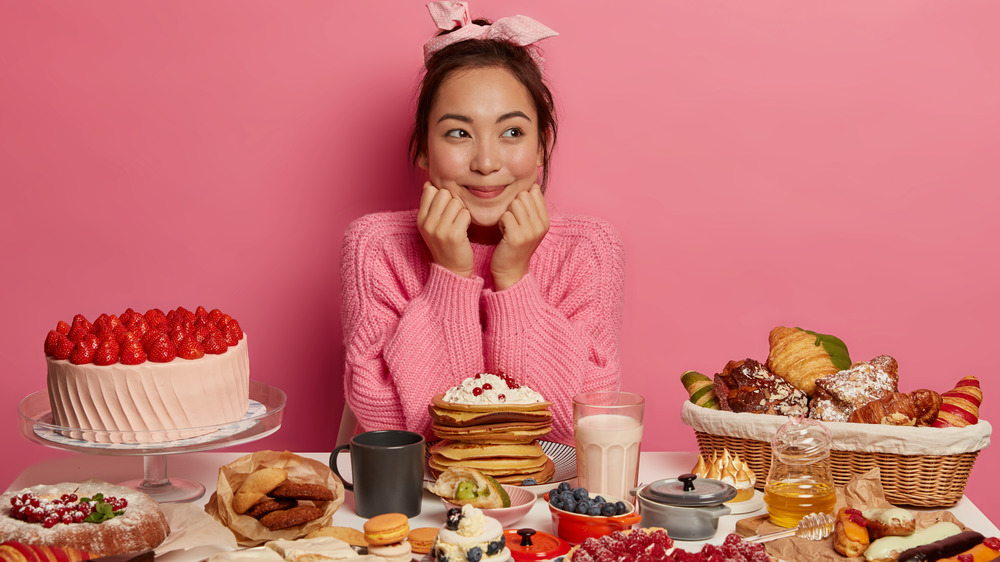 woman surrounded by desserts