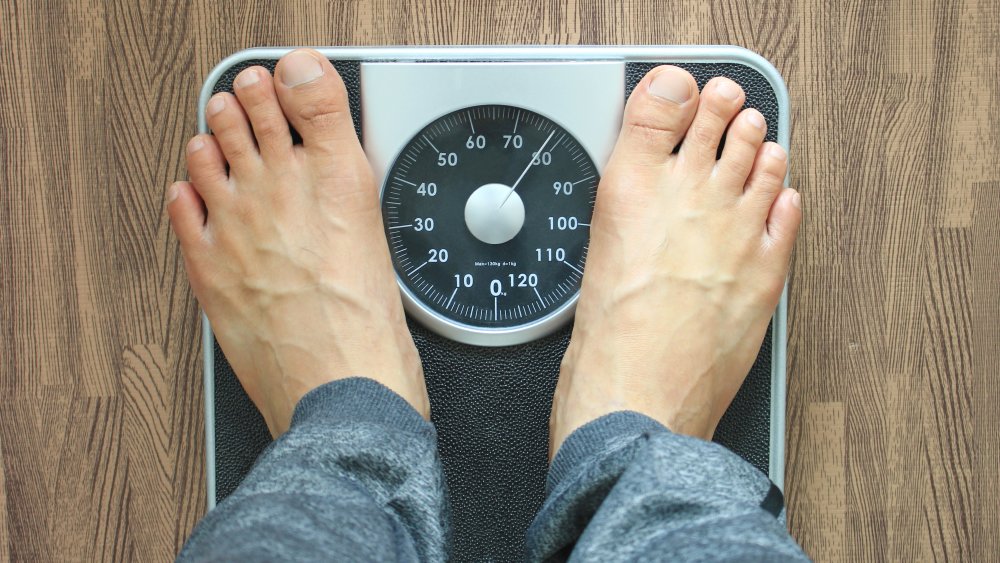 Man on scale gaining weight