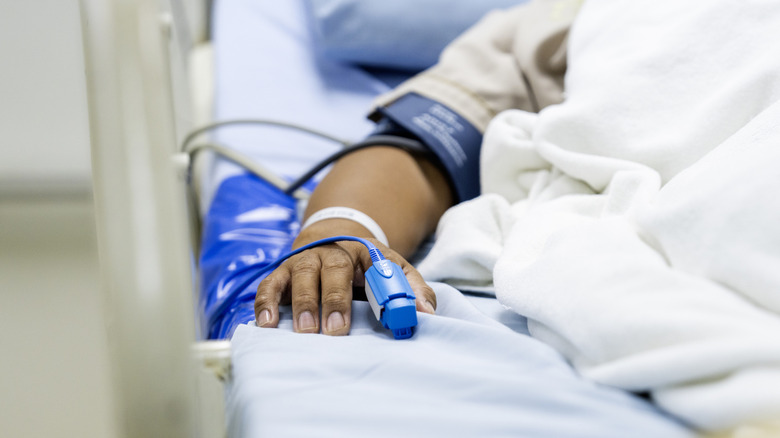 Hand of a sick person on a hospital bed