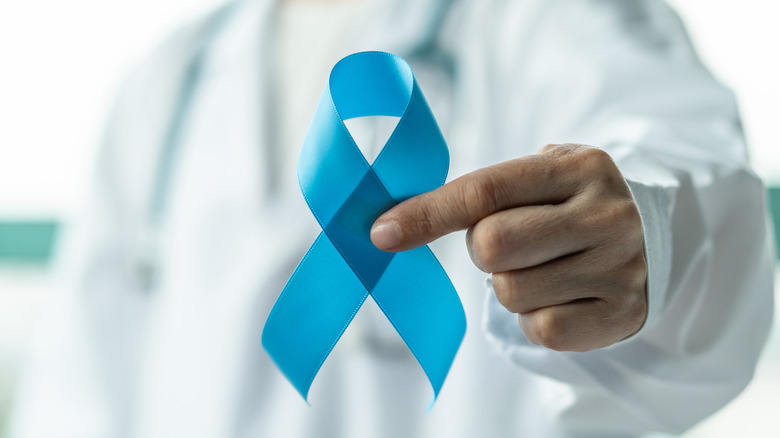 Doctor holding up blue diabetes ribbon