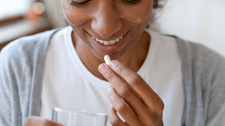 Woman taking a probiotic supplement