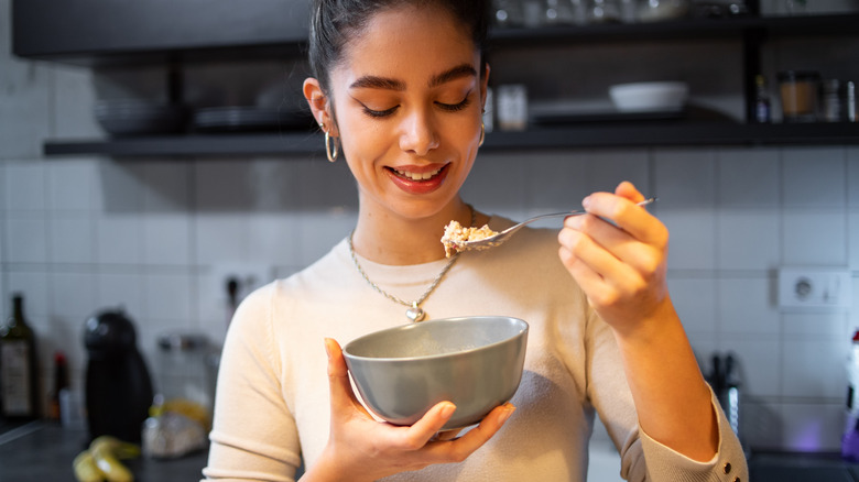 Woman eating bowl of oatmeal