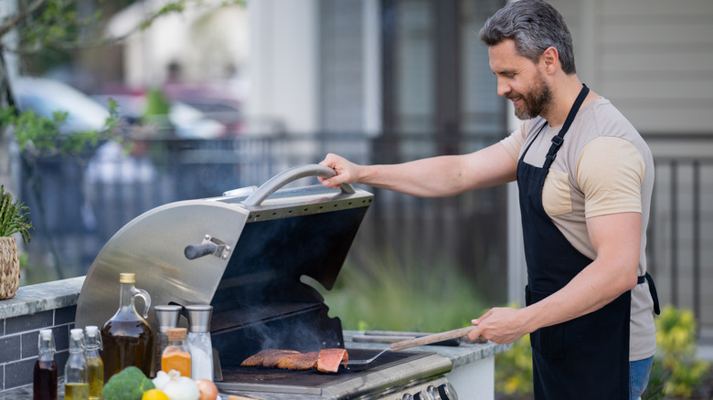 A man grilling food on his outdoor grill