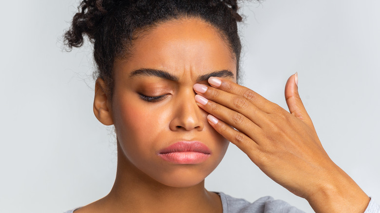 african girl with a sty covering left eye