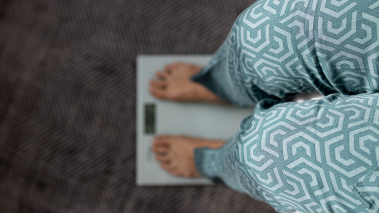 woman standing on scale at home