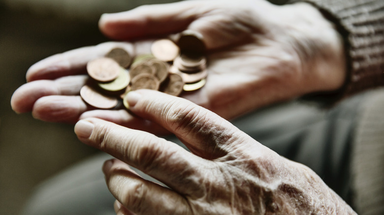 man's hands holding a variety of small coins