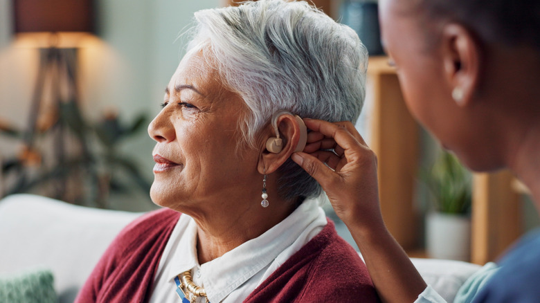 older woman having hearing aid put into her ear