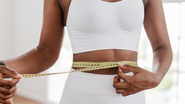 woman measures waistline