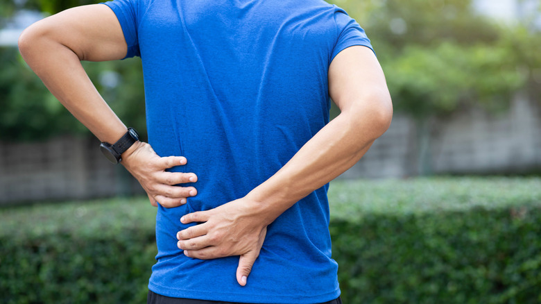 Man holding onto lower back