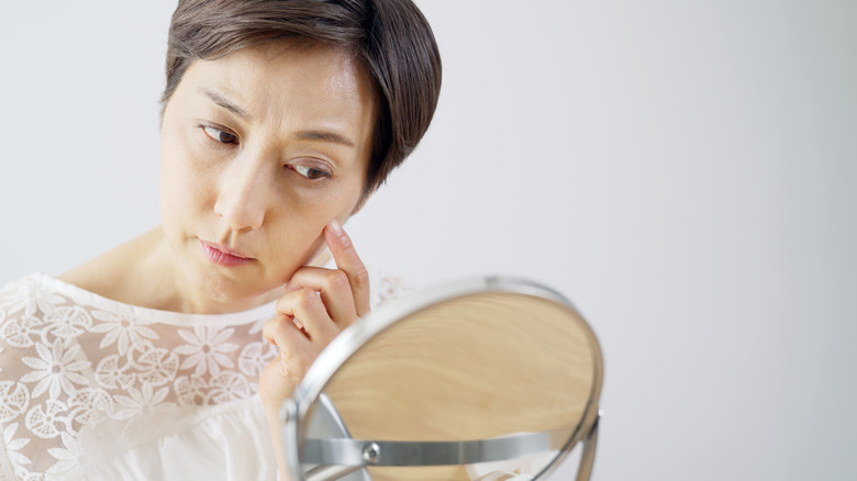 woman looking at skin