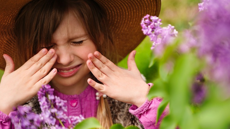 Girl rubbing her eyes from pollen