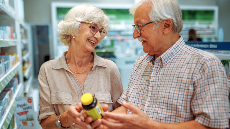 older couple choosing a vitamin or supplement in store