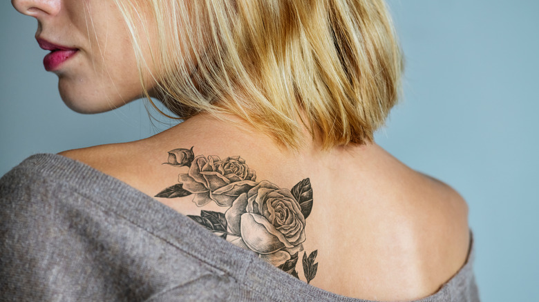 Woman with rose tattoo on shoulder