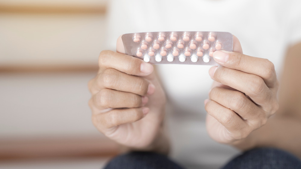 Woman holding blister pack of birth control pills