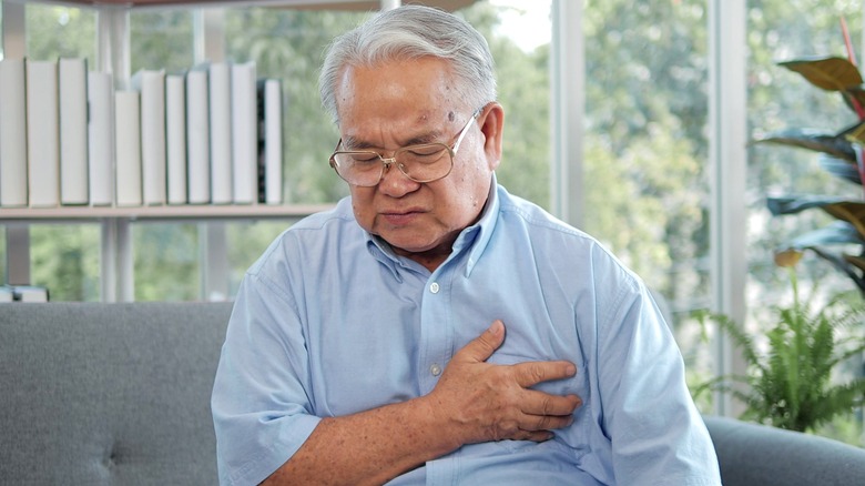 Senior man holding hand to chest