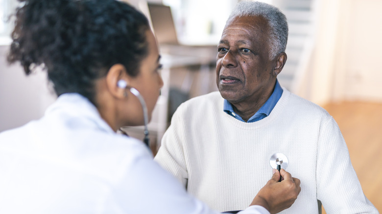 Doctor examining patient with stethoscope