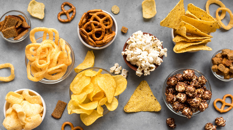 An array of salty snacks against a gray background
