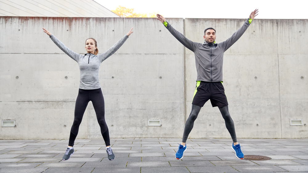 two people doing jumping jacks