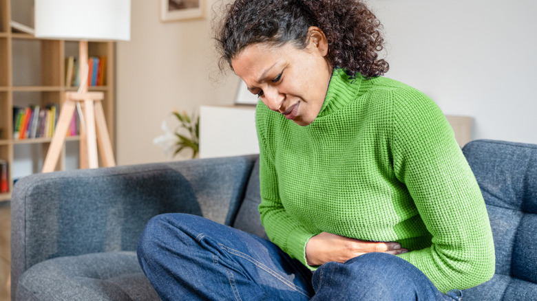 Woman holding stomach in pain