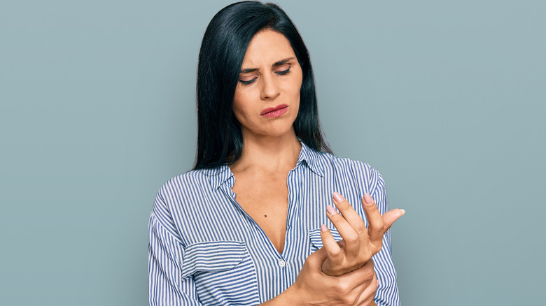 woman holding hand in pain