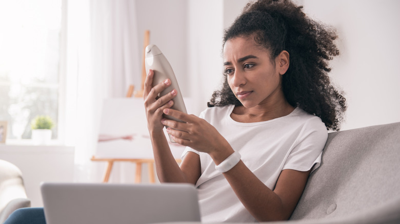 woman reading tanning lotion label