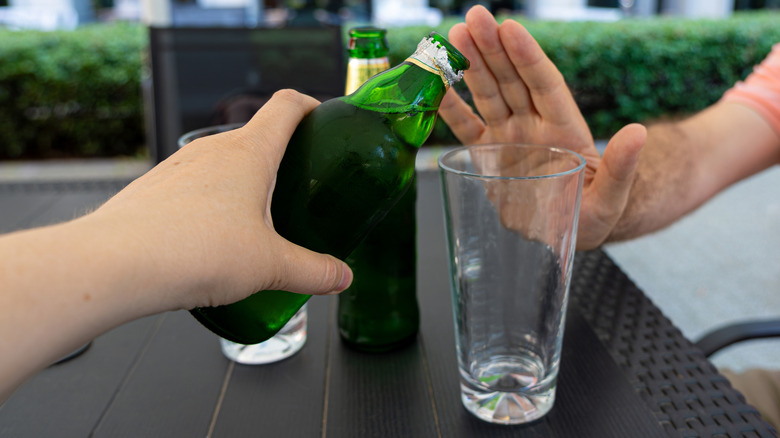 hand refusing glass of beer