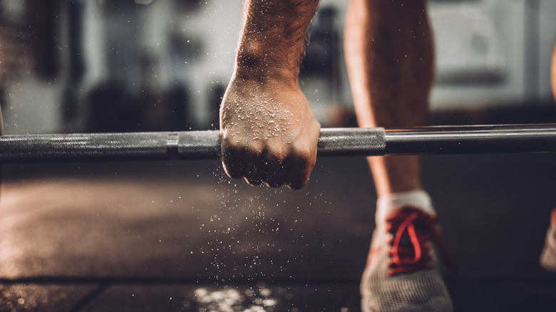 man's hands on barbell