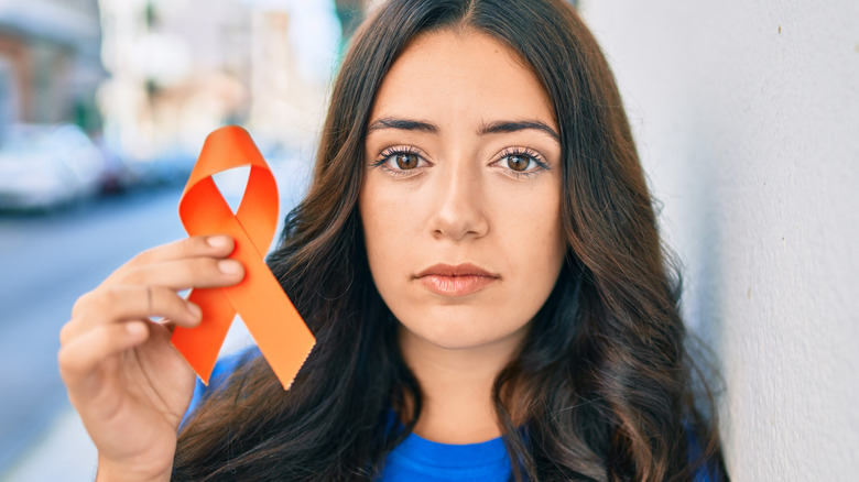 Young woman holding orange ribbon