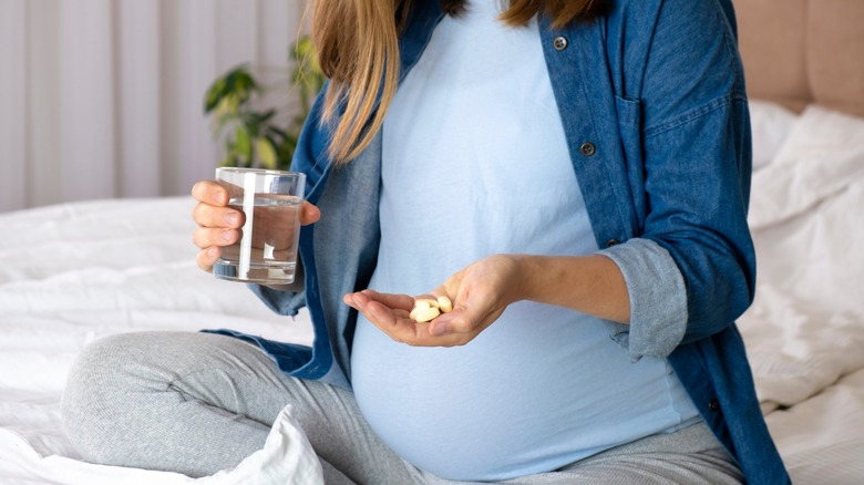 pregnant woman holding pills