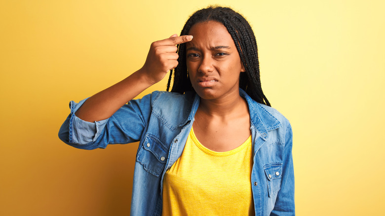 Black woman pointing at acne