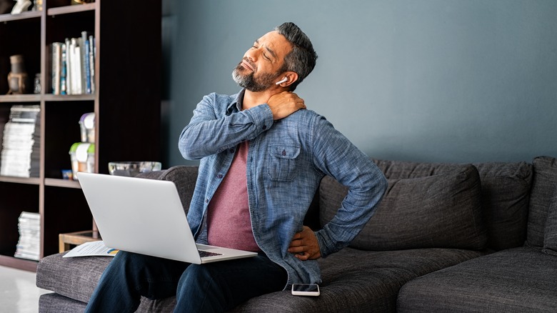 man holding his shoulder and back