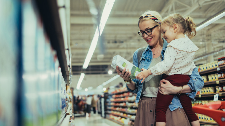 woman and child shopping for boxed milk