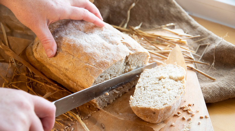 man cutting fresh baked bread 