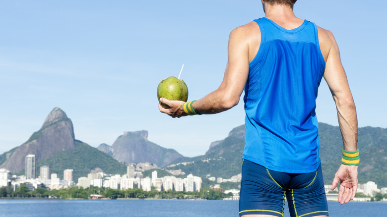 Athlete holding a green coconut in his hand