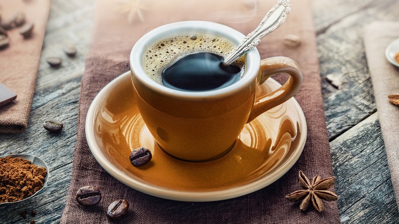 cup of coffee with beans on table