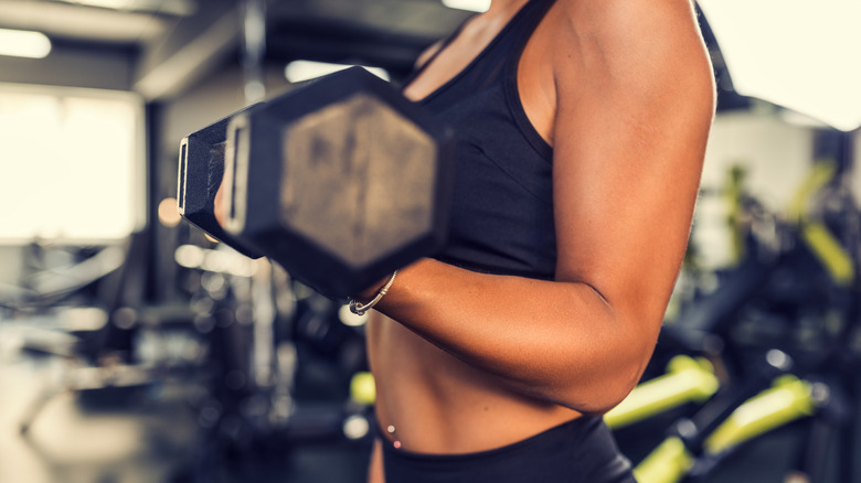 side view of woman lifting weight