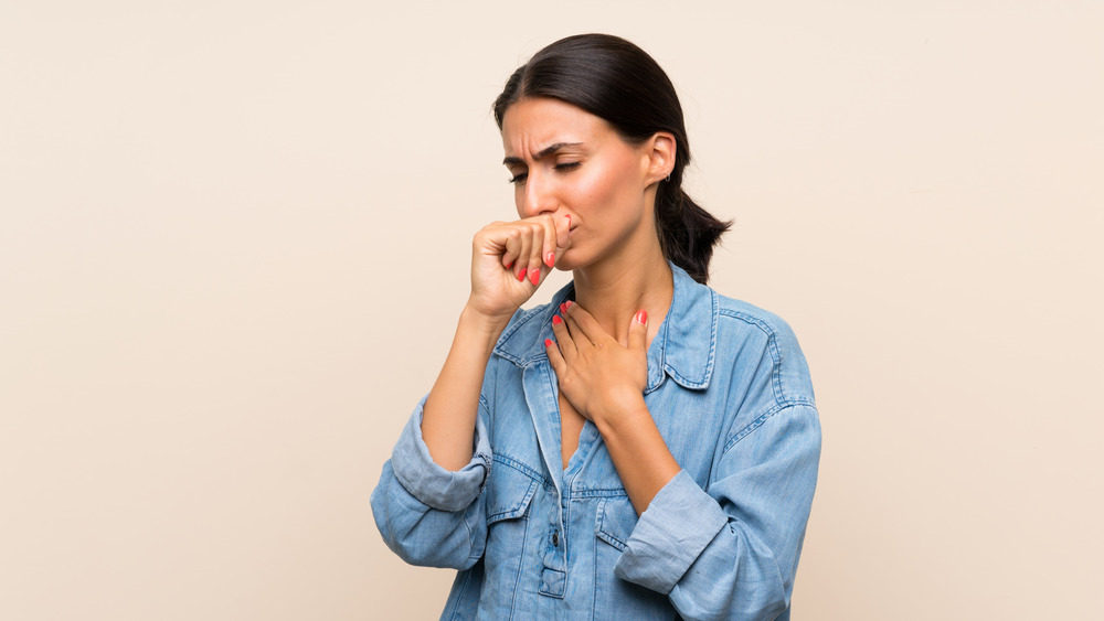 Woman coughing into her hand