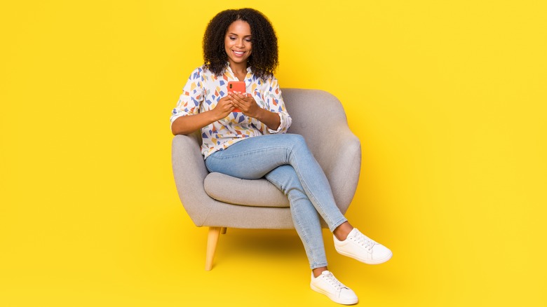 a woman sitting in a chair with her legs crossed